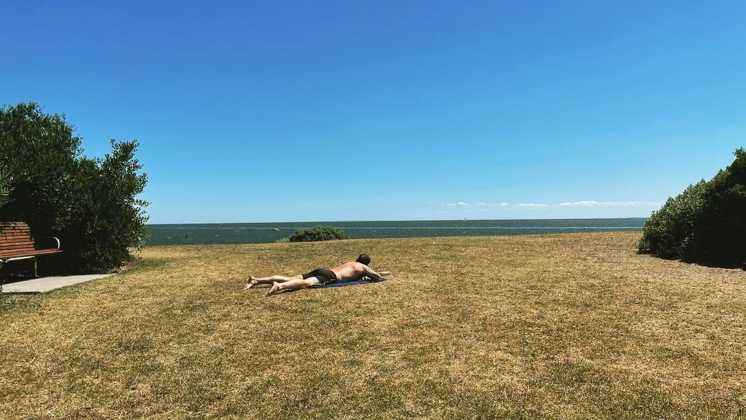 Laying on the grassy beach, soak up the sun and watch the waves crash against th